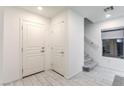 Bright entryway features ceramic tile flooring, staircase, and two storage closets with white doors at 8092 Haywood Estate Ave, Las Vegas, NV 89113