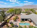 Aerial view of a backyard pool area with a tiki hut, lounge chairs, and mature landscaping at 8125 Soledad Canyon St, Las Vegas, NV 89131
