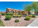 Charming single-story home with desert landscaping, featuring mature plants and stone accents at 819 Arrowhead Trl, Henderson, NV 89002
