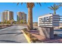 Community entrance sign with palm trees and lush landscaping under a clear blue sky at 8255 One Las Vegas Blvd # 504, Las Vegas, NV 89123