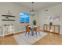 Cozy dining area with modern light fixture, wood floors, and view from the window at 8255 One Las Vegas Blvd # 504, Las Vegas, NV 89123