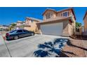 Inviting two-story home with a tile roof, attached garage, and a neatly maintained front yard with a long driveway at 8370 Lost Lake Ct, Las Vegas, NV 89147