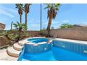 Backyard view featuring a custom pool and spa surrounded by desert landscaping and a privacy wall at 9923 Sierra Canyon Way, Las Vegas, NV 89147