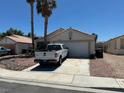 Single story home on a street with a driveway, garage, and low maintenance front yard at 1409 Velvet Leaf Dr, North Las Vegas, NV 89032