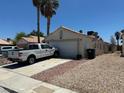 Single story home on a street with a driveway and low maintenance front yard and back yard at 1409 Velvet Leaf Dr, North Las Vegas, NV 89032