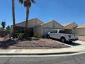 Single story home with white truck in driveway, palm trees, and low maintenance landscaping at 1409 Velvet Leaf Dr, North Las Vegas, NV 89032