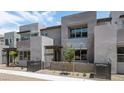 A modern townhouse with a gray exterior, large windows, a small yard, and architectural details at 1467 Melodic Lark Ln, Las Vegas, NV 89138