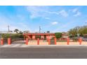 Single-story home featuring a well-kept lawn, privacy hedges, and a charming iron gate at 147 Cervantes St, Las Vegas, NV 89101