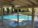 Covered patio featuring a ceiling fan and outdoor dining area with a pool view at 2817 Whispering Wind Dr, Las Vegas, NV 89117