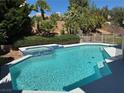 Backyard pool with blue tile spa and lush landscaping for privacy at 2817 Whispering Wind Dr, Las Vegas, NV 89117