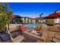 Inviting backyard with a fire pit, seating area, and pool, perfect for outdoor entertaining with spa and play area at 2822 Ashby Ave, Las Vegas, NV 89102