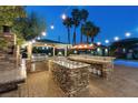 Impressive outdoor kitchen featuring a grill, sink, and countertop space with evening lighting for backyard gatherings at 2822 Ashby Ave, Las Vegas, NV 89102