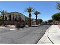 Gated community entrance with lush palm trees and meticulously maintained landscaping at 357 Whispering Tree Ave, Las Vegas, NV 89183