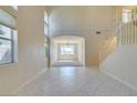 Bright living room featuring soaring ceilings, tile flooring, and a staircase at 3766 Port Ritchey St, Las Vegas, NV 89147
