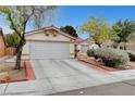 Charming single-story home with a well-maintained front yard and attached two car garage at 5220 Shasta Daisy St, North Las Vegas, NV 89031