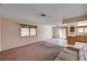 Bright living room with an open concept to the kitchen, featuring carpet and tile flooring at 5274 Somerset Dr, Las Vegas, NV 89120