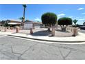 Charming single-story home featuring a gated entrance, red brick accents, and mature trees in a sunny neighborhood at 5460 Conville Pl, Las Vegas, NV 89120