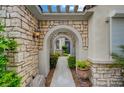 Stone-paved walkway leads through arched entrances to a charming blue front door at 729 Sir James Bridge Way, Las Vegas, NV 89145