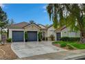 Charming single-story home with a stone accent wall and a spacious driveway leading to a three-car garage at 729 Sir James Bridge Way, Las Vegas, NV 89145