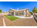 An appealing backyard, featuring an airy covered patio, manicured lawn, and gravel landscaping at 7410 Bridlehorne Ave, Las Vegas, NV 89131