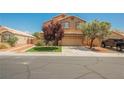 Two-story home featuring a manicured lawn, desert landscaping, and a neutral-toned exterior at 7690 Morning Lake Dr, Las Vegas, NV 89131