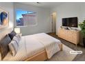 Cozy main bedroom with soft carpet, natural light, a dresser, and a view of the neighborhood at 983 Plantain Lily Ave, Las Vegas, NV 89183