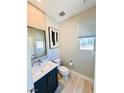 Powder room featuring a floating vanity with modern hardware and light wood floors at 10280 Midnight Meteor Ave, Las Vegas, NV 89166