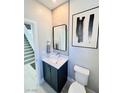 Modern powder room featuring gray paint, stylish fixtures and hardware and light wood floors at 10280 Midnight Meteor Ave, Las Vegas, NV 89166