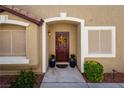 Inviting front entrance with a decorative wreath, potted plants, and manicured landscaping at 10336 Birch Bluff Ln, Las Vegas, NV 89145