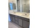 Bathroom featuring double sinks with quartz countertops and gray cabinets at 11407 Ethereal Landing Ave, Las Vegas, NV 89138