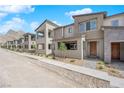 Exterior view showcasing a row of modern townhomes with desert landscaping and mountain views at 11407 Ethereal Landing Ave, Las Vegas, NV 89138
