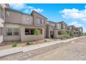 Image displays new townhomes with coordinated architecture, rock landscaping, and easy sidewalk access at 11407 Ethereal Landing Ave, Las Vegas, NV 89138