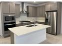 Modern kitchen featuring stainless steel appliances, kitchen island, and gray cabinets at 11407 Ethereal Landing Ave, Las Vegas, NV 89138