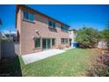 A well-maintained backyard with green artificial turf, concrete patio, and block wall at 1405 Gilbert Creek Ave, North Las Vegas, NV 89031