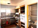 Kitchen featuring an old sink, cabinetry with marble effect countertops, oven, dishwasher and empty shelves at 212 Hinkle St, Las Vegas, NV 89107