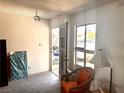 A sparse living room with an orange chair and a view to the outside through a door with bars at 212 Hinkle St, Las Vegas, NV 89107
