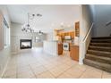 Open-concept living space with tile floors, fireplace, staircase, and adjacent kitchen at 2407 Belt Buckley Dr, Henderson, NV 89002