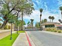Community entrance featuring well-maintained landscaping, mature trees, and a secure gated entry at 2451 Tour Edition Dr, Henderson, NV 89074