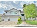 Beautiful two-story house featuring desert landscaping, a three-car garage, and manicured front lawn at 2451 Tour Edition Dr, Henderson, NV 89074