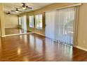 Bright living room featuring hardwood floors, a ceiling fan, and mirrored wall at 2609 Sierra Sage St, Las Vegas, NV 89134