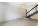 Open living area features tile flooring and a staircase with black iron railing at 3260 Longford Way, Las Vegas, NV 89121