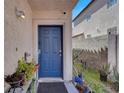 Charming blue front door surrounded by lush greenery, complementing the home's inviting entrance at 3389 Commendation Dr, Las Vegas, NV 89117