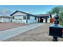Inviting single-story home with a long driveway, mature landscaping, and decorative flower boxes at 407 Tiger Lily Way, Henderson, NV 89015