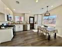 Bright kitchen with white cabinets, stainless steel appliances, and dining area at 407 Tiger Lily Way, Henderson, NV 89015