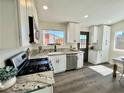 Updated kitchen with stainless steel appliances, granite countertops, and ample cabinet space at 407 Tiger Lily Way, Henderson, NV 89015