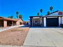 A single-story home boasting a black and white carport, simple desert landscaping, and a clear blue sky at 4681 Via San Rafael, Las Vegas, NV 89103