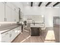 Modern kitchen with white cabinetry, stainless steel appliances, and an island with bar seating at 5725 El Royale Ct, Las Vegas, NV 89149