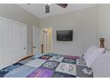 Cozy bedroom with a ceiling fan, television, and neutral paint at 5833 Craigmore Ln, North Las Vegas, NV 89031