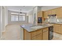 Bright kitchen features granite countertops, a large island, and stainless steel appliances at 5833 Craigmore Ln, North Las Vegas, NV 89031