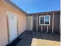 View of front entrance with white storm door and brown window trim at 613 Buchanan Ave, Henderson, NV 89015